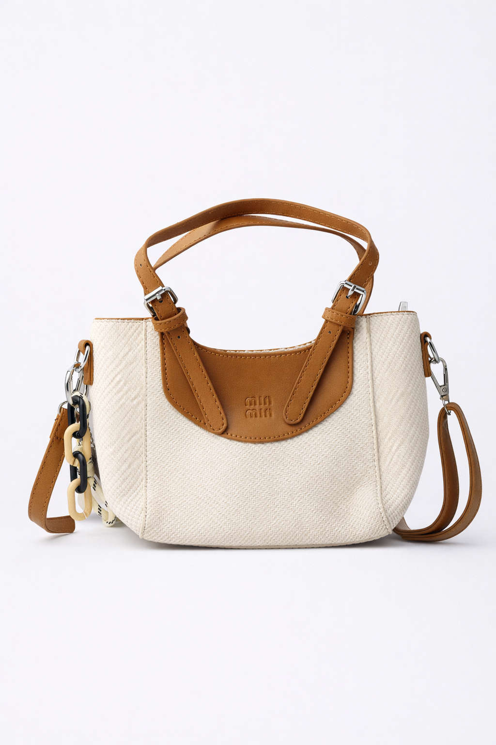 White handbag with brown leather accents on a white background