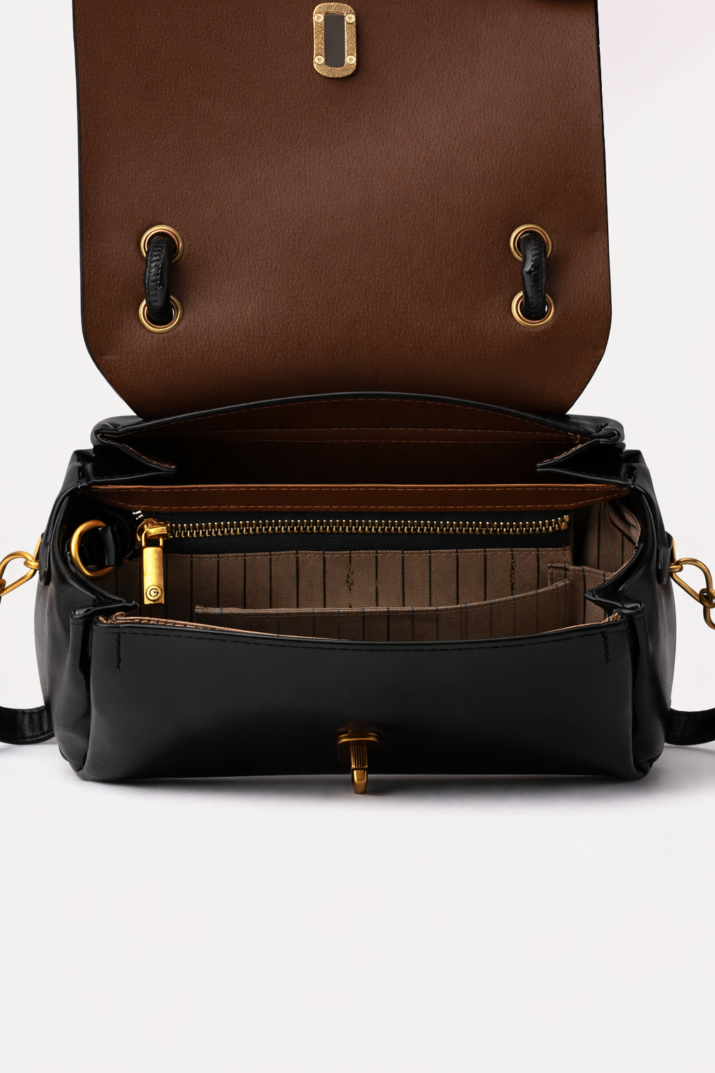 Black leather bag with gold zippers and hardware on a white background